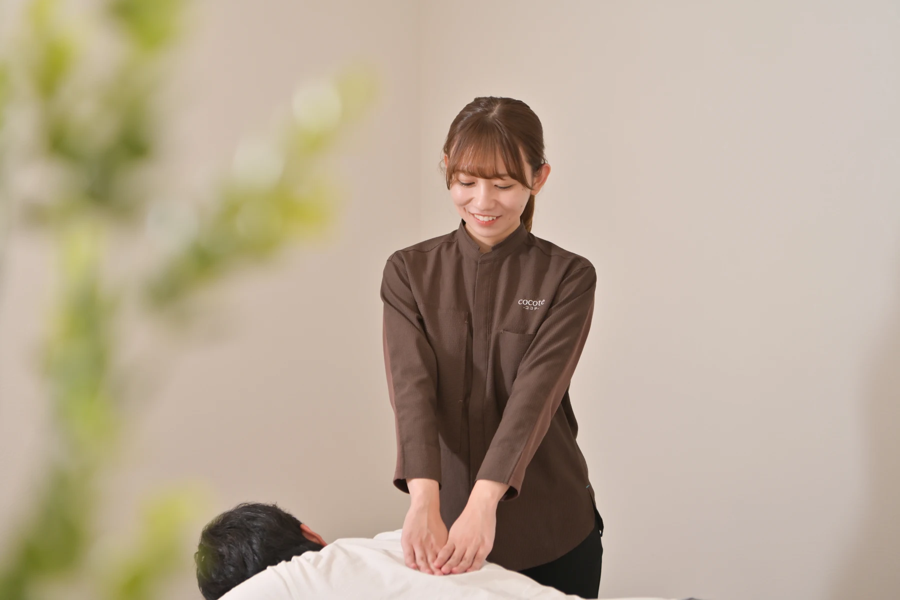 お客様の背中を丁寧にもみほぐすcocoteスタッフ