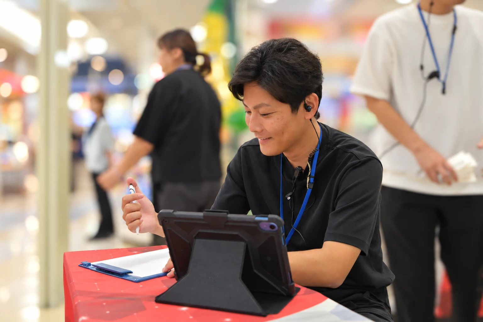 タブレットを使いご案内する男性スタッフ